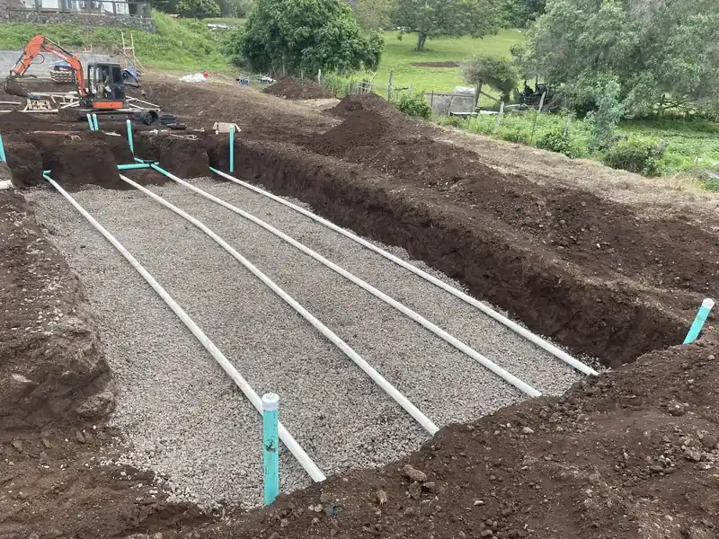 Leach field trenches with perforated pipe bedded in gravel on an Upcountry Maui pasture lot